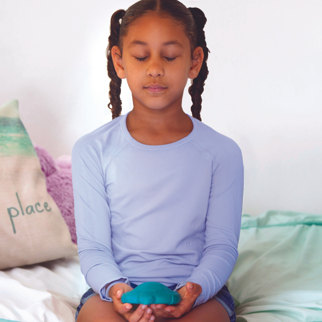 Young girl meditating with Zenimal
